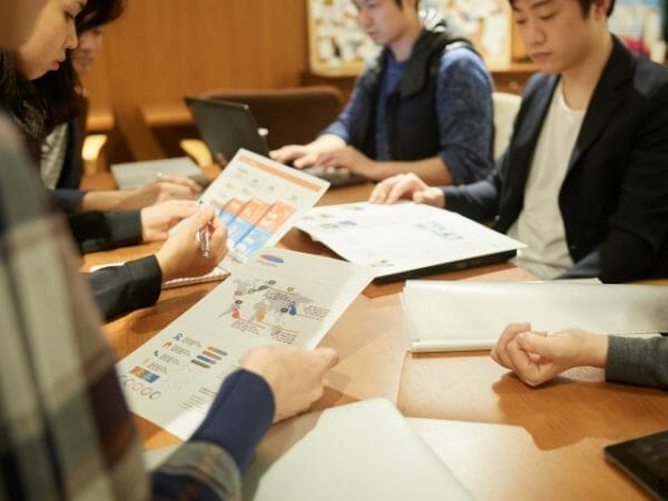 食後の会議中に眠気に襲われている会社員のイメージ